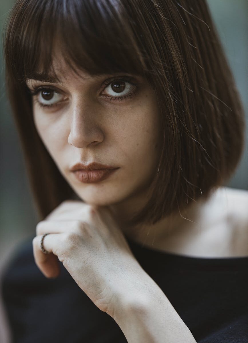 woman looking up with hand on chin